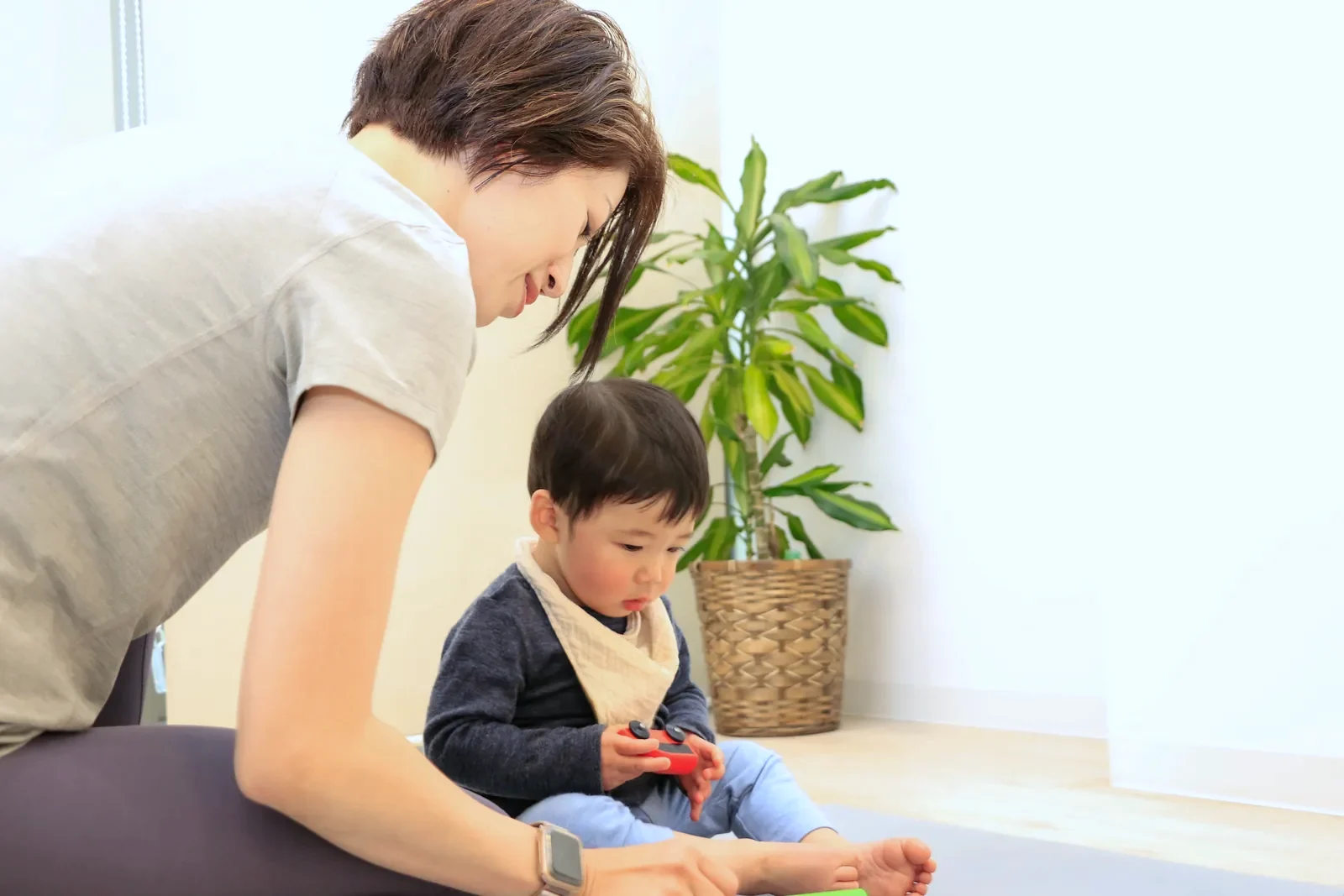 スタジオで、トレーナーが小さなお子様に笑顔で話しかけている様子