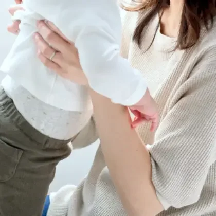 子どもを抱き上げる母親の手元